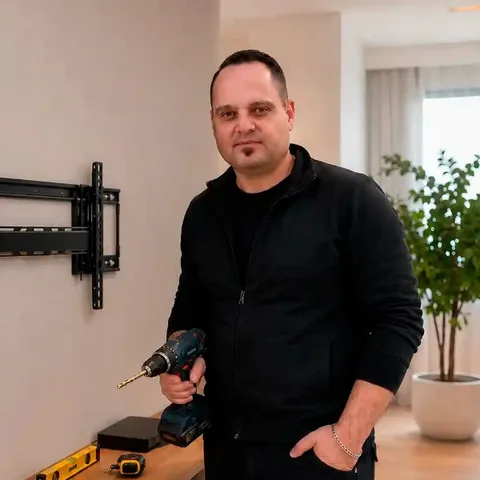 מתקין טלוויזיות במגדל העמק עם מקדחה וכלי עבודה להתקנת מסכים על הקיר