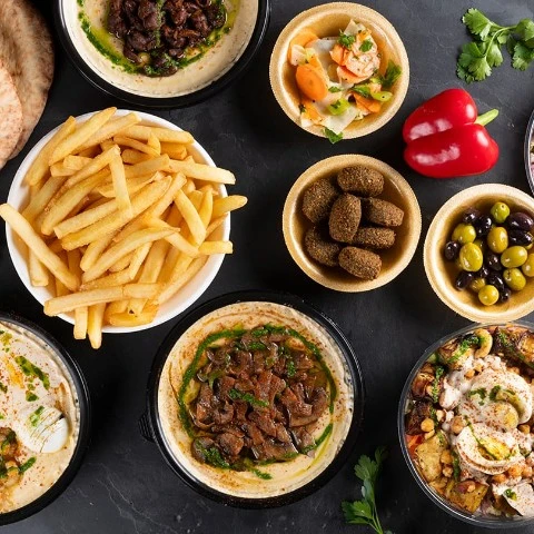 מבחר מנות חומוס, פלאפל, צ׳יפס וסלטים בחומוסיה כשרה למהדרין במגדל העמק