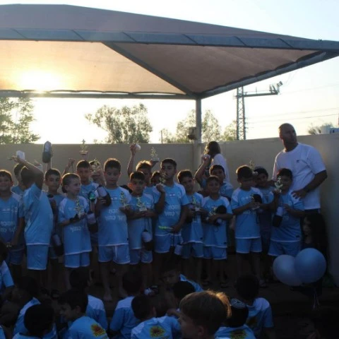 ילדי חוג הכדורגל במגדל העמק בטקס סיום עם גביעים ומוטי קריספיל
